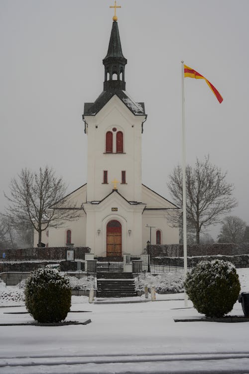 A church in the snow with a flag flying