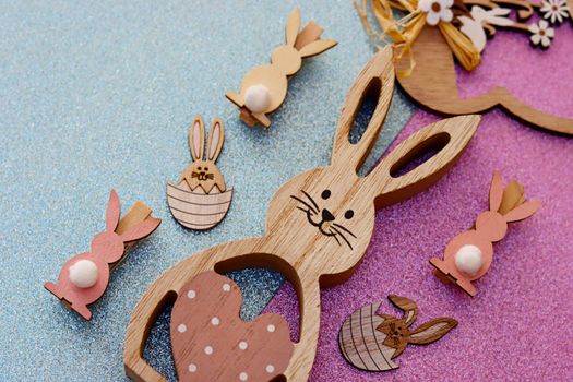 Charming wooden Easter bunny decorations on a vibrant glitter background, perfect for seasonal celebrations.