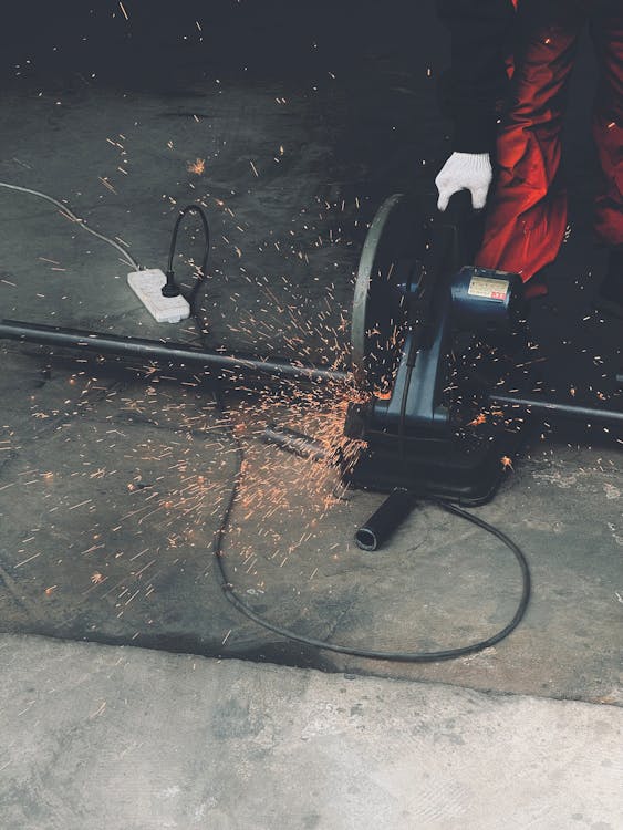 A person using a grinder to cut metal