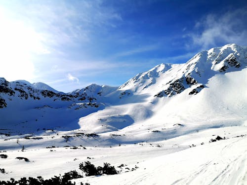 A view of a snowy mountain range with a blue sky