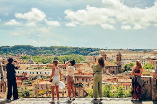 A group of people standing on a balcony overlooking a city