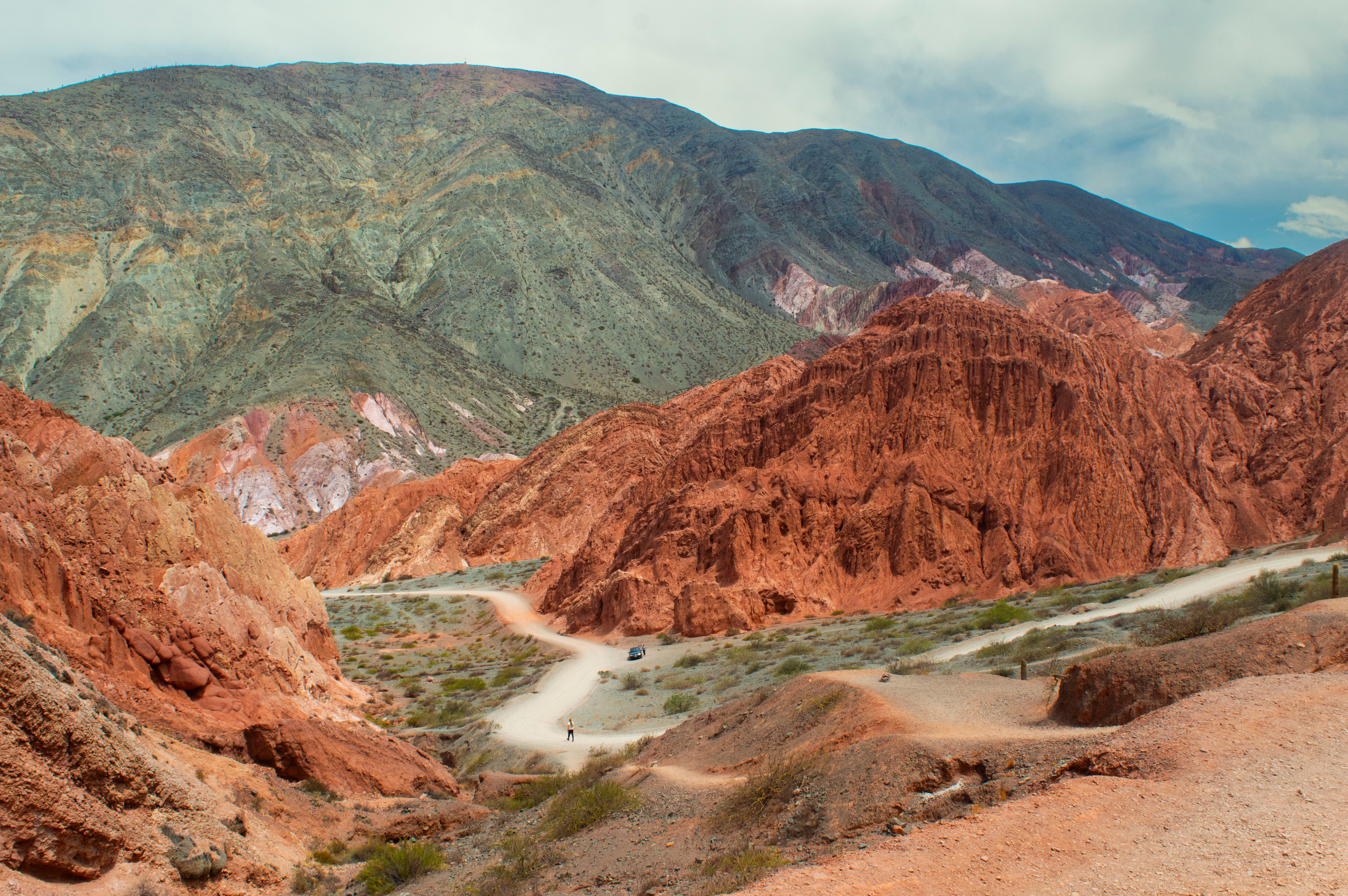 Explore the vibrant red hills and winding dirt roads of Jujuy, Argentina, a stunning natural landscape.