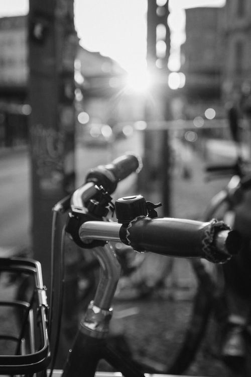 Free Close-up of bicycle handlebars in black and white with urban sunlight Stock Photo