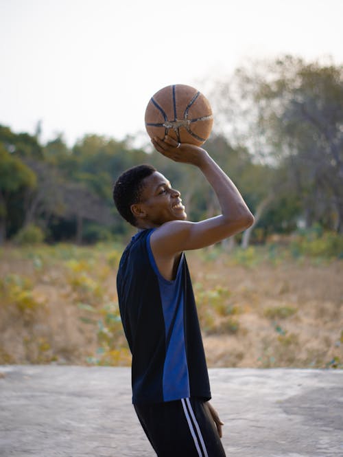 A young boy is holding a basketball in his hand