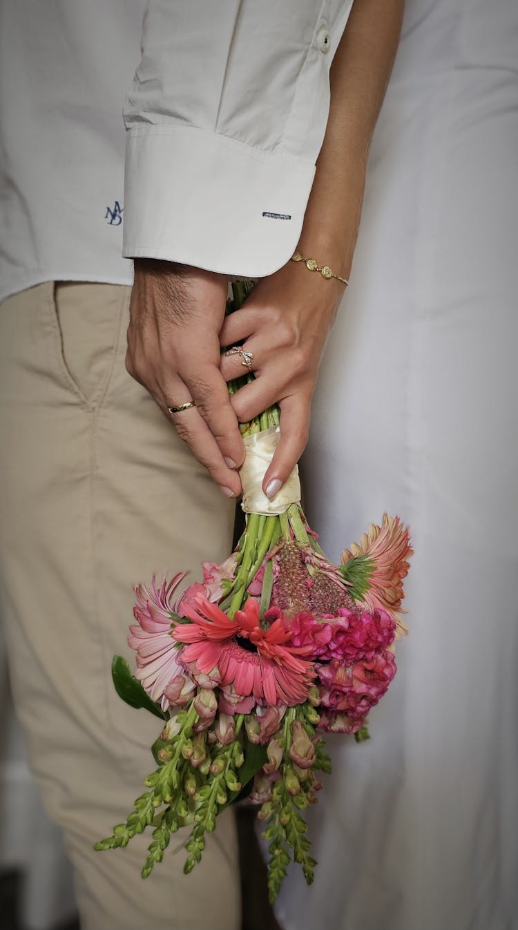 Woman And Man Holding Bouquet Of Flowers Together