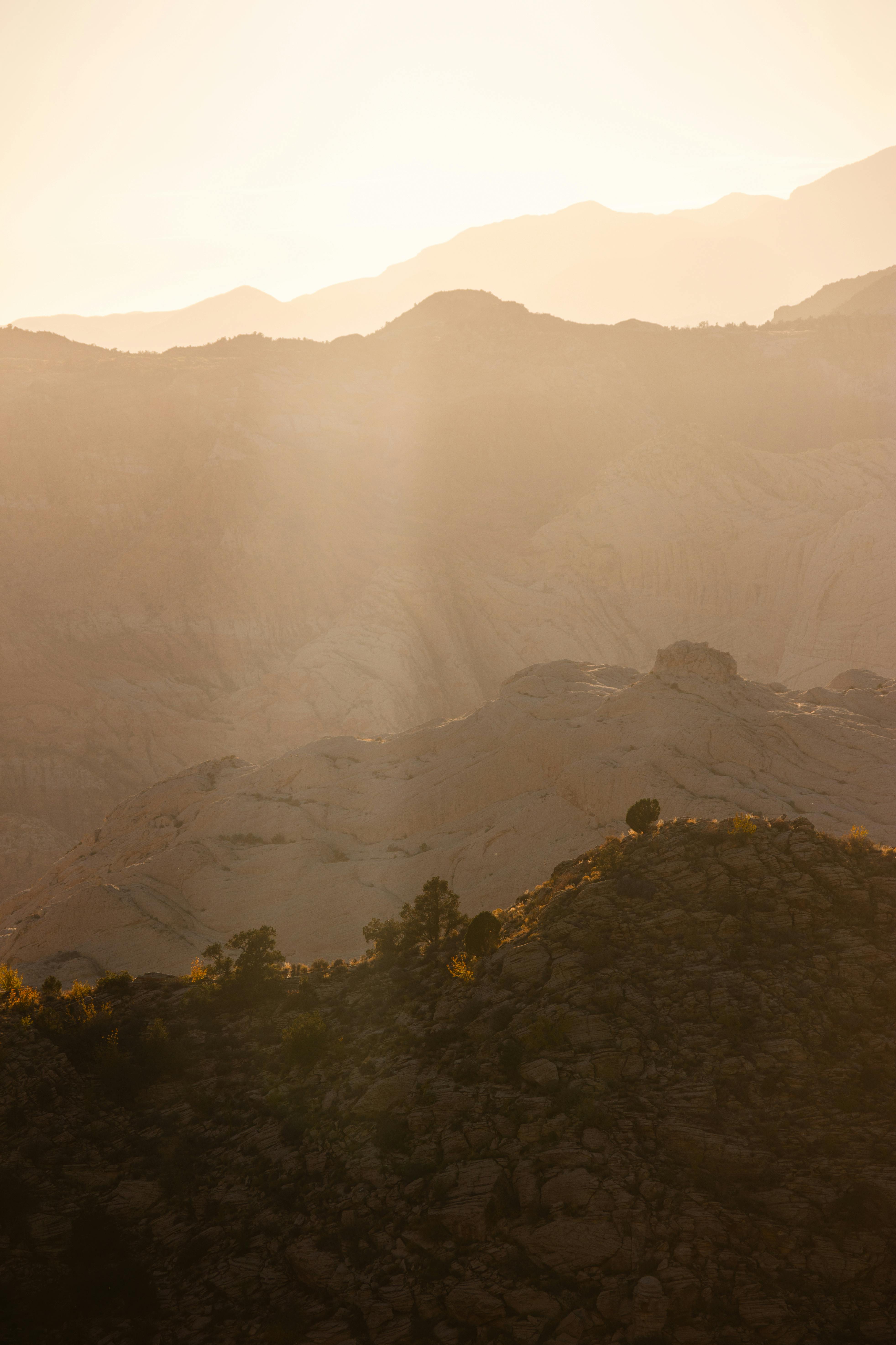Golden sunrise over Utah's sandstone formations casting stunning silhouettes and sun rays.
