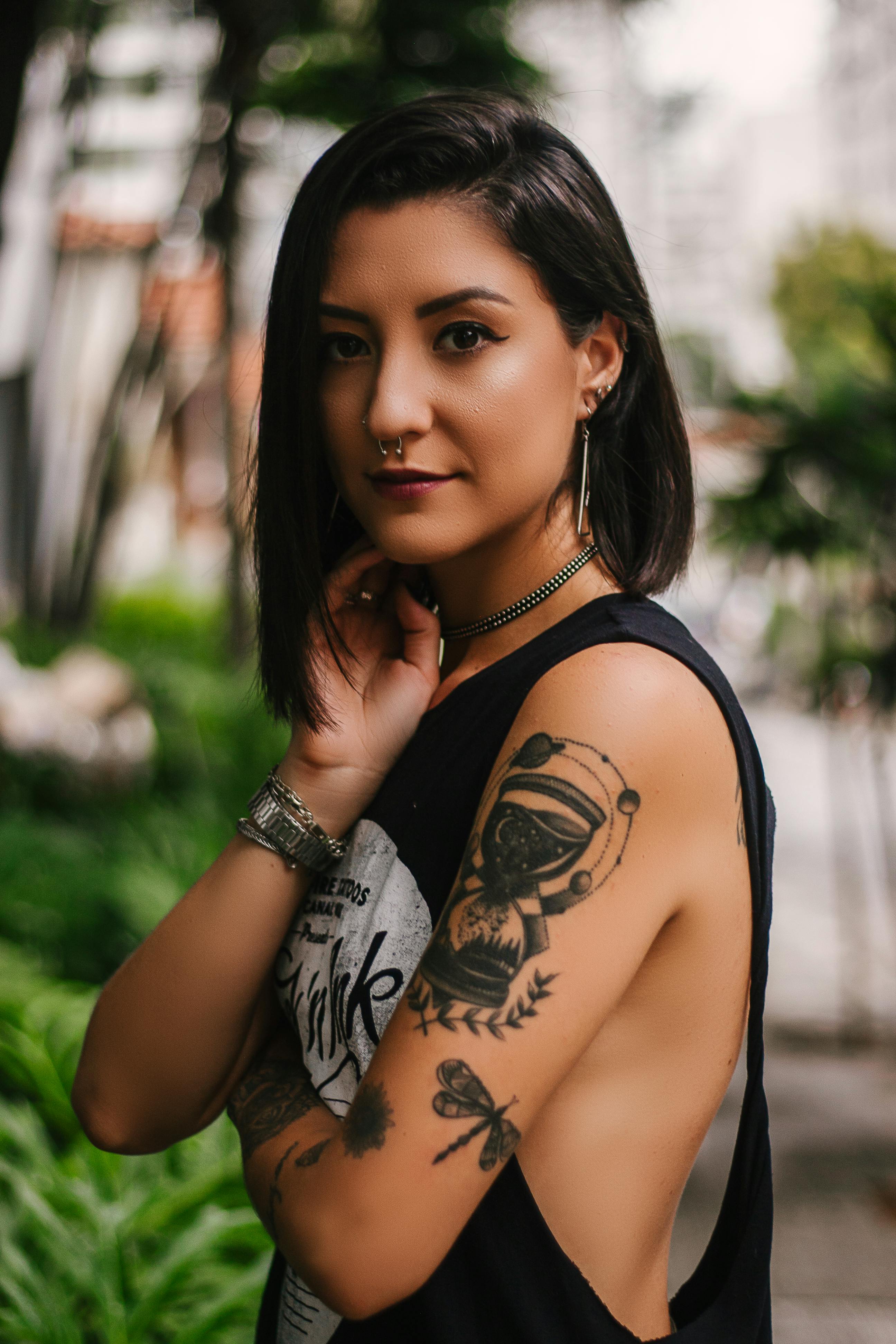 photo of woman wearing sleeveless top with tattoos and piercings