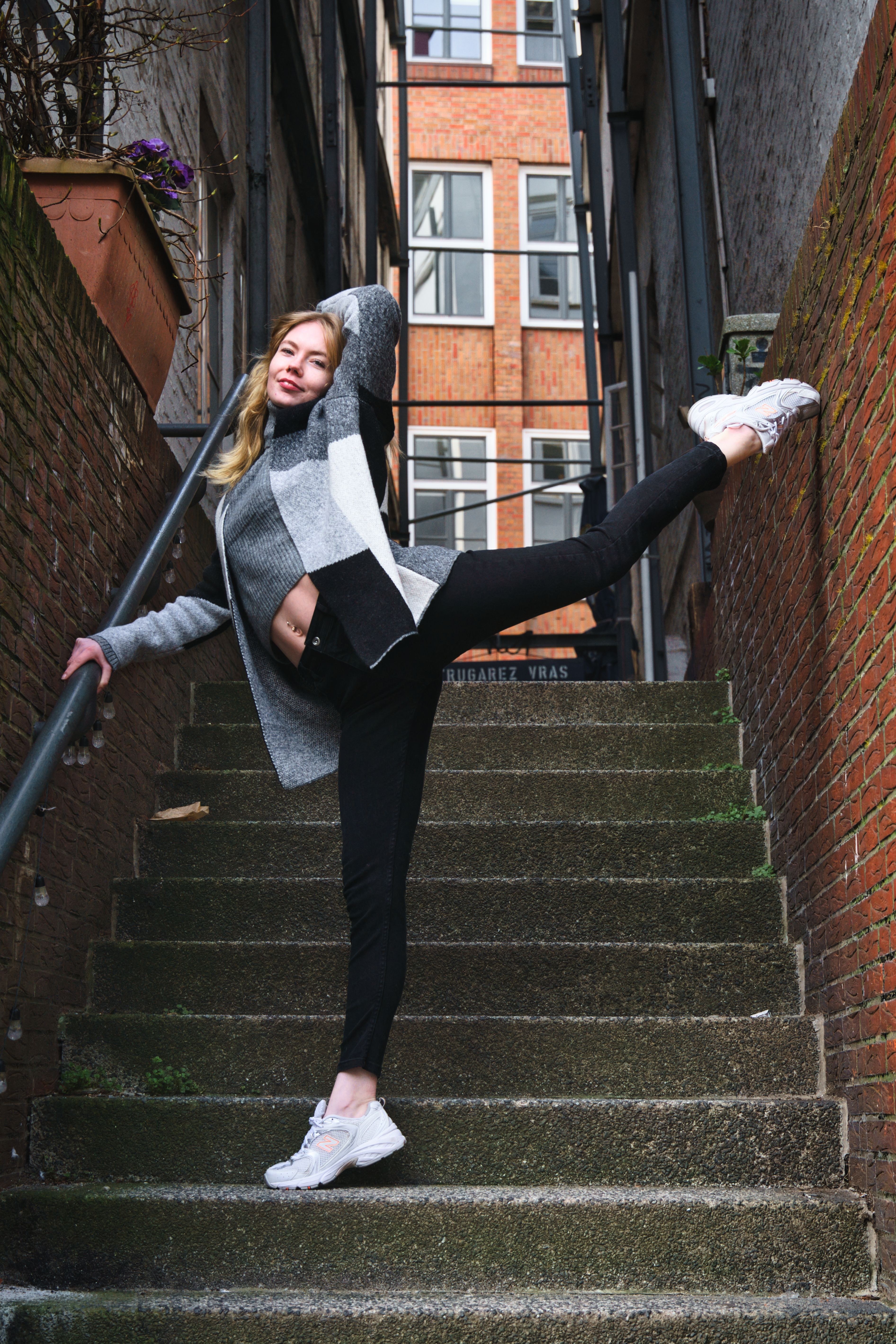 Graceful woman posing elegantly on a staircase in Hamburg, Germany.