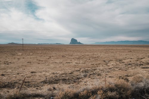 A barren landscape with a mountain in the distance