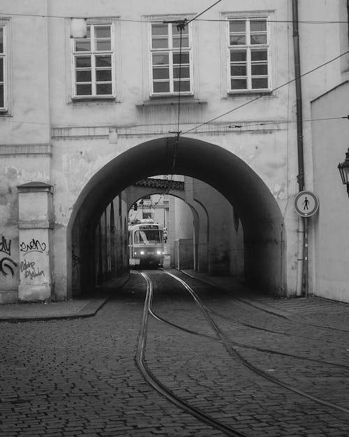 A black and white photo of a train going through a tunnel