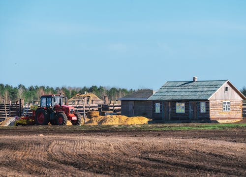 A tractor is parked in front of a farm house