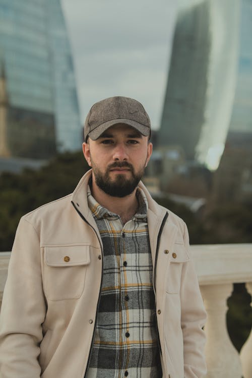 Portrait of Man Wearing Cap Among Glass Buildings 