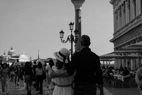 A couple walking down a street with a lamp post