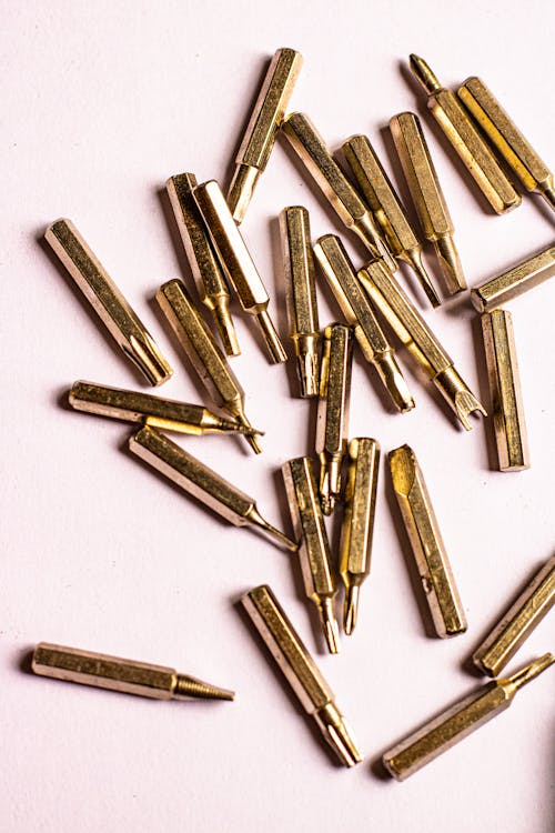 A bunch of brass bullet caps on a white surface