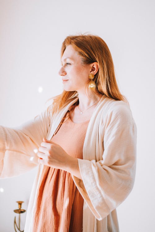 A woman in an orange dress holding a light bulb