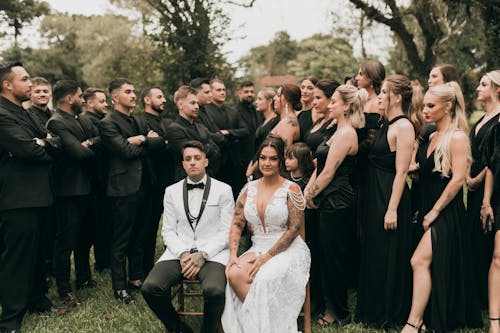 A wedding party posing for a photo in the grass