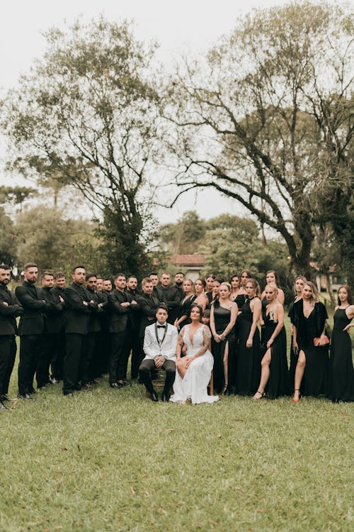 A wedding party posing for a photo in the grass