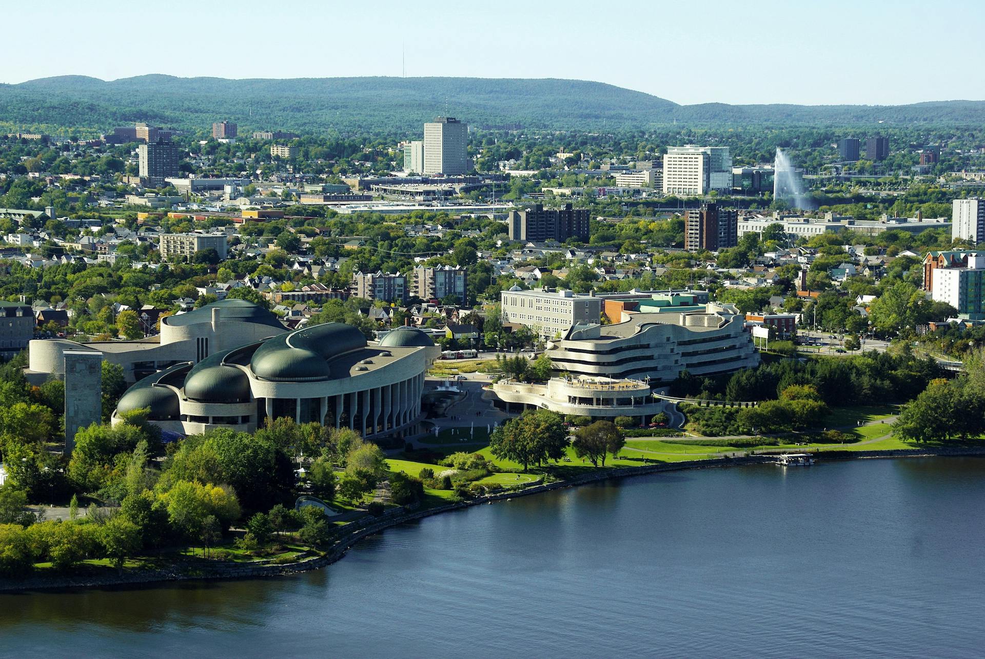 Aerial cityscape of Ottawa and Gatineau with modern architecture and lush greenery.