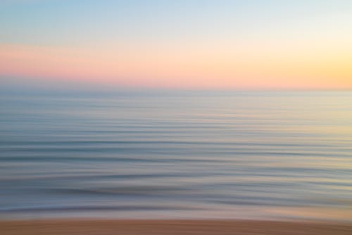 A long exposure photograph of the ocean at sunset