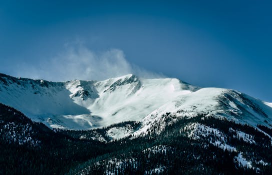 晴朗的蓝天下，戏剧性的雪山景观展现了大自然的壮丽