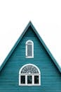 A blue house with a white window and a blue roof