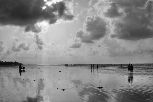 Free A tranquil B&W shot of people walking on Mandarmani Beach, India. Stock Photo