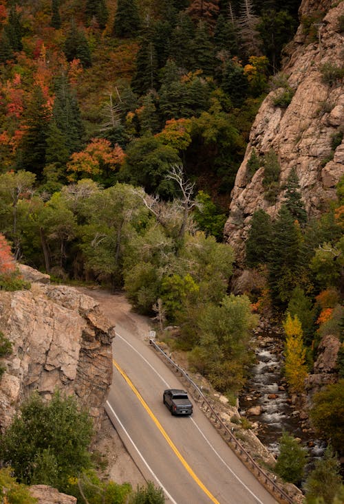 A car driving down a mountain road in the fall