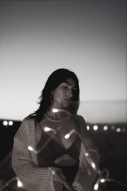 A woman in a sweater with lights around her