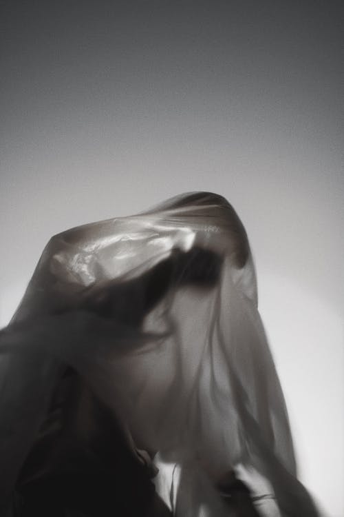 A person in a white veil with a black background