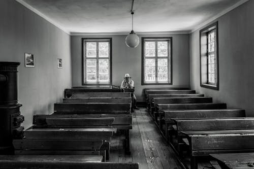 A black and white photo of a church with empty pews