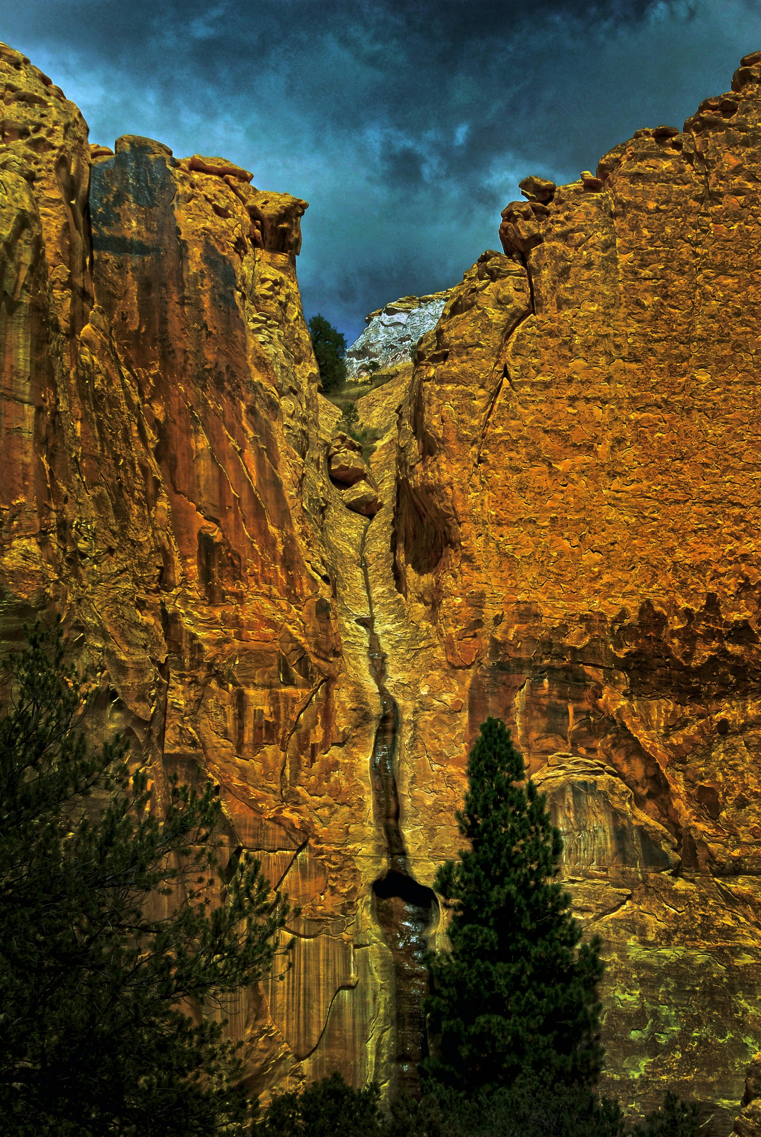在黑暗的暴风雨天空下，雄伟的峡谷悬崖呈现出充满活力的色调