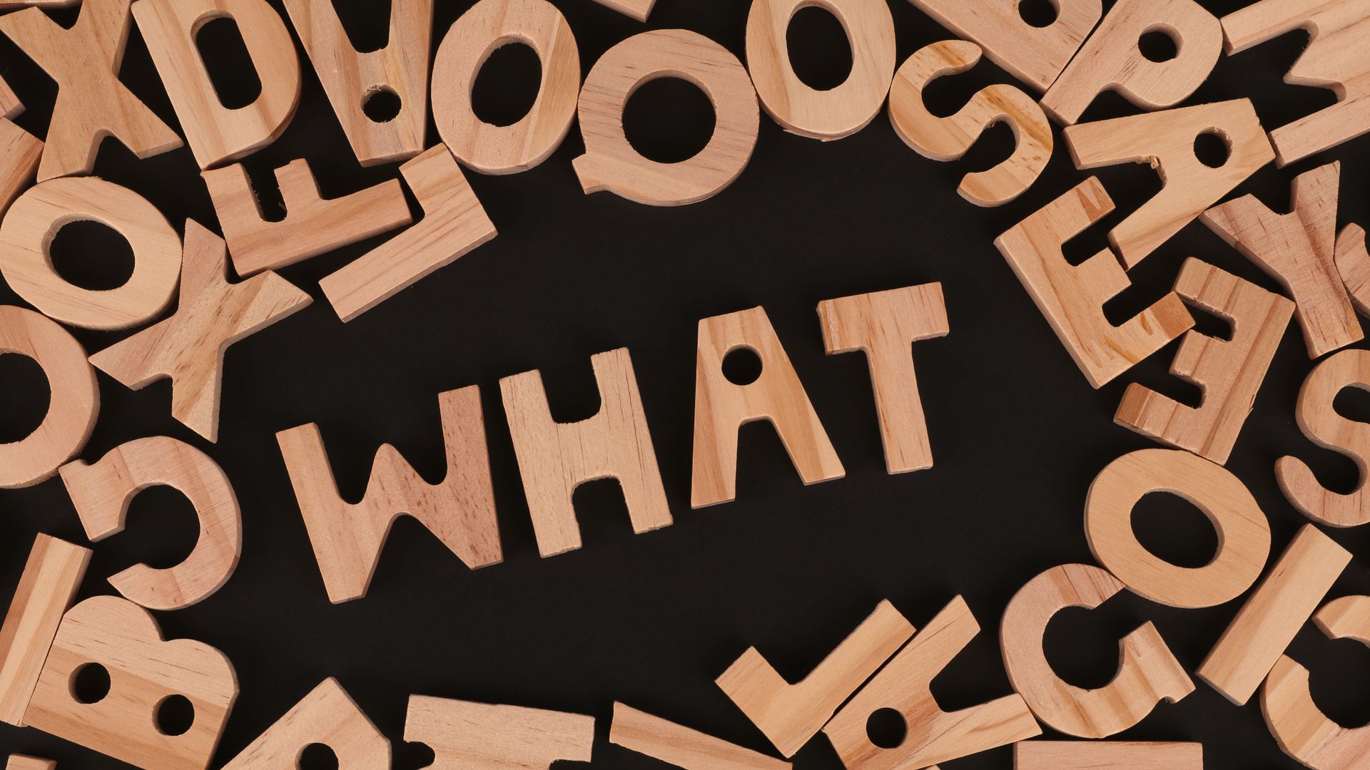 What is Modafinil? Unlocking the Mystery of This Smart Drug Artistic arrangement of wooden letters spelling 'WHAT' on a black background, offering creative inspiration.