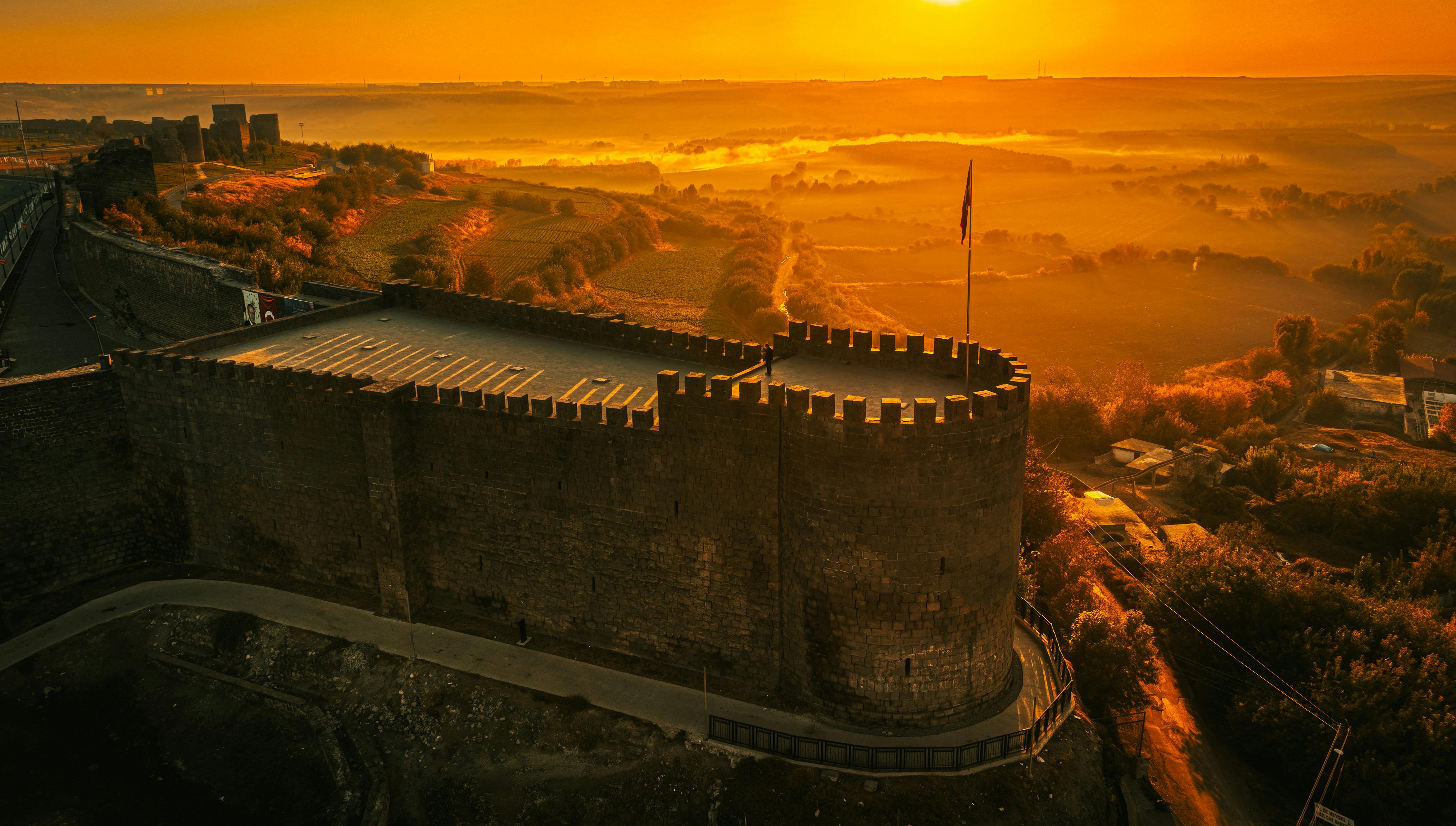 Stunning aerial view of historic Diyarbakır Fortress illuminated by sunrise in Türkiye.