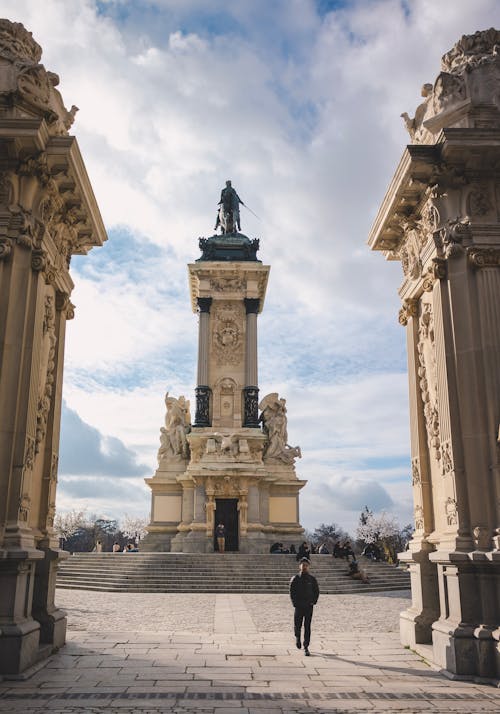 A person walking through a doorway in front of a monument