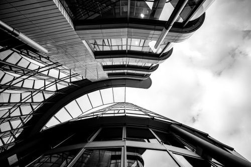 Free Striking black and white photograph of modern urban architecture featuring glass and steel facades reaching into the sky. Stock Photo