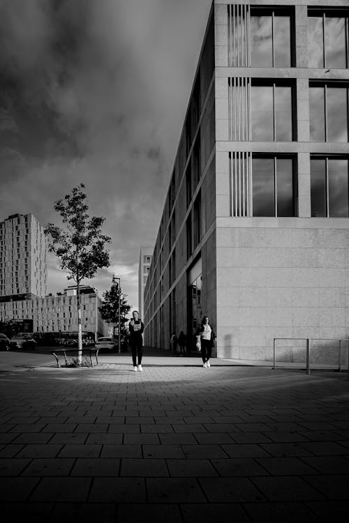 Black and white photograph of people walking in front of a building