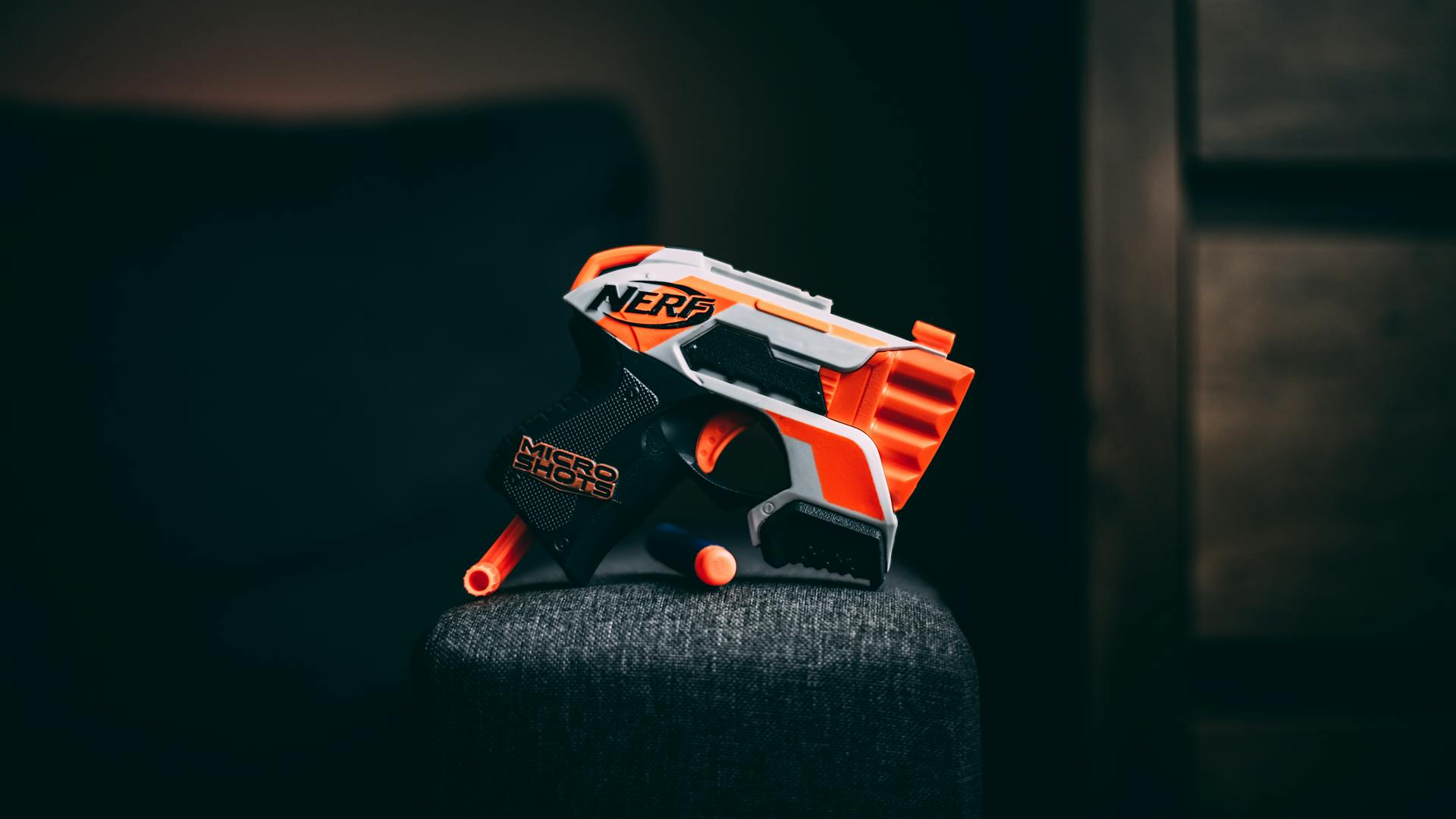 Brightly colored Nerf toy gun against a dark backdrop, emphasizing the orange and gray design.