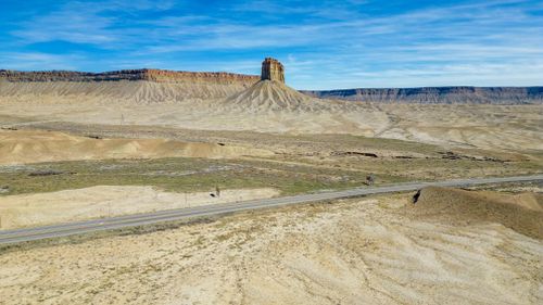 Free A breathtaking view of a road through Towaoc's unique desert terrain under a clear blue sky. Stock Photo