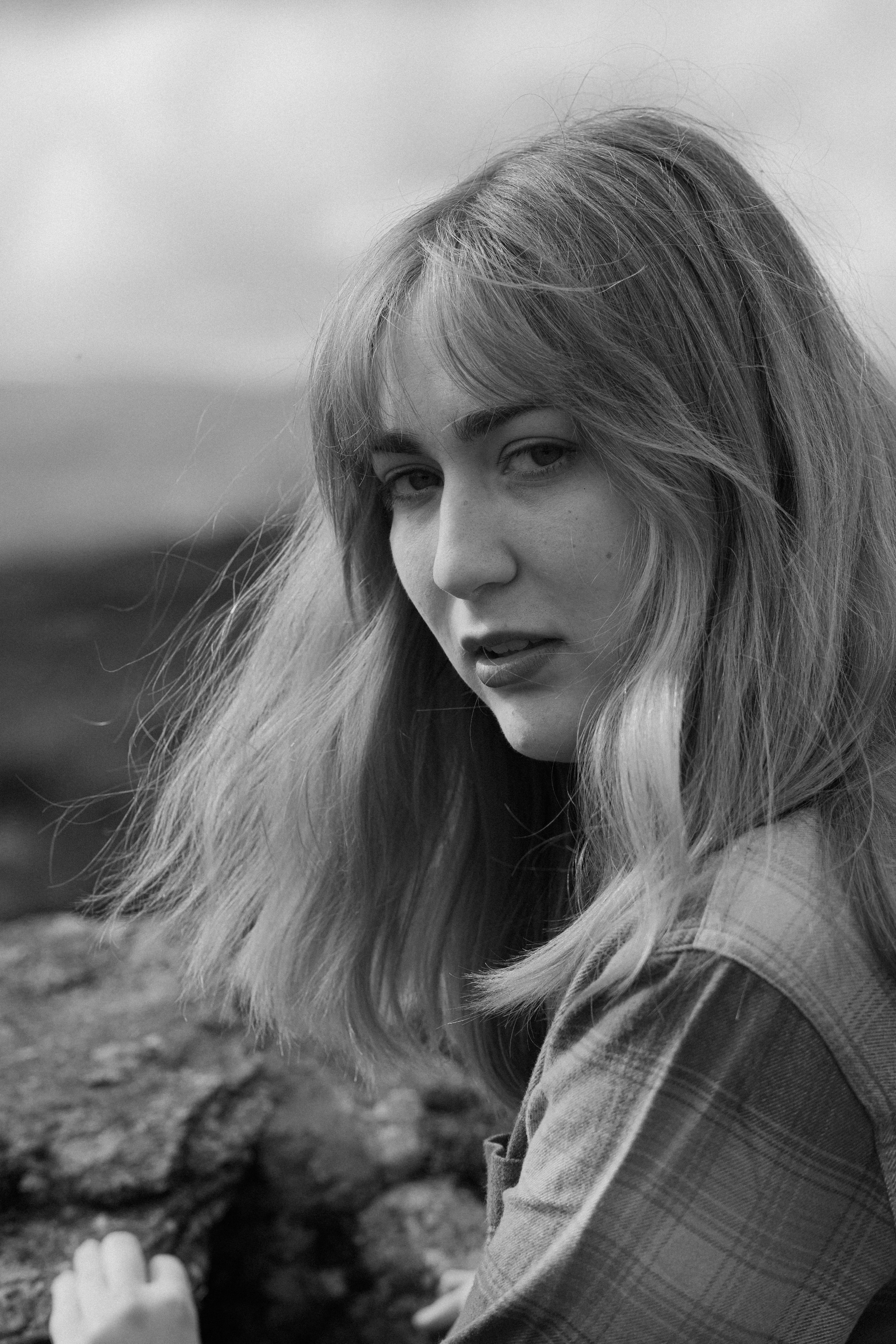 Woman gazes thoughtfully in black and white, capturing the mood of Windermere's natural beauty.