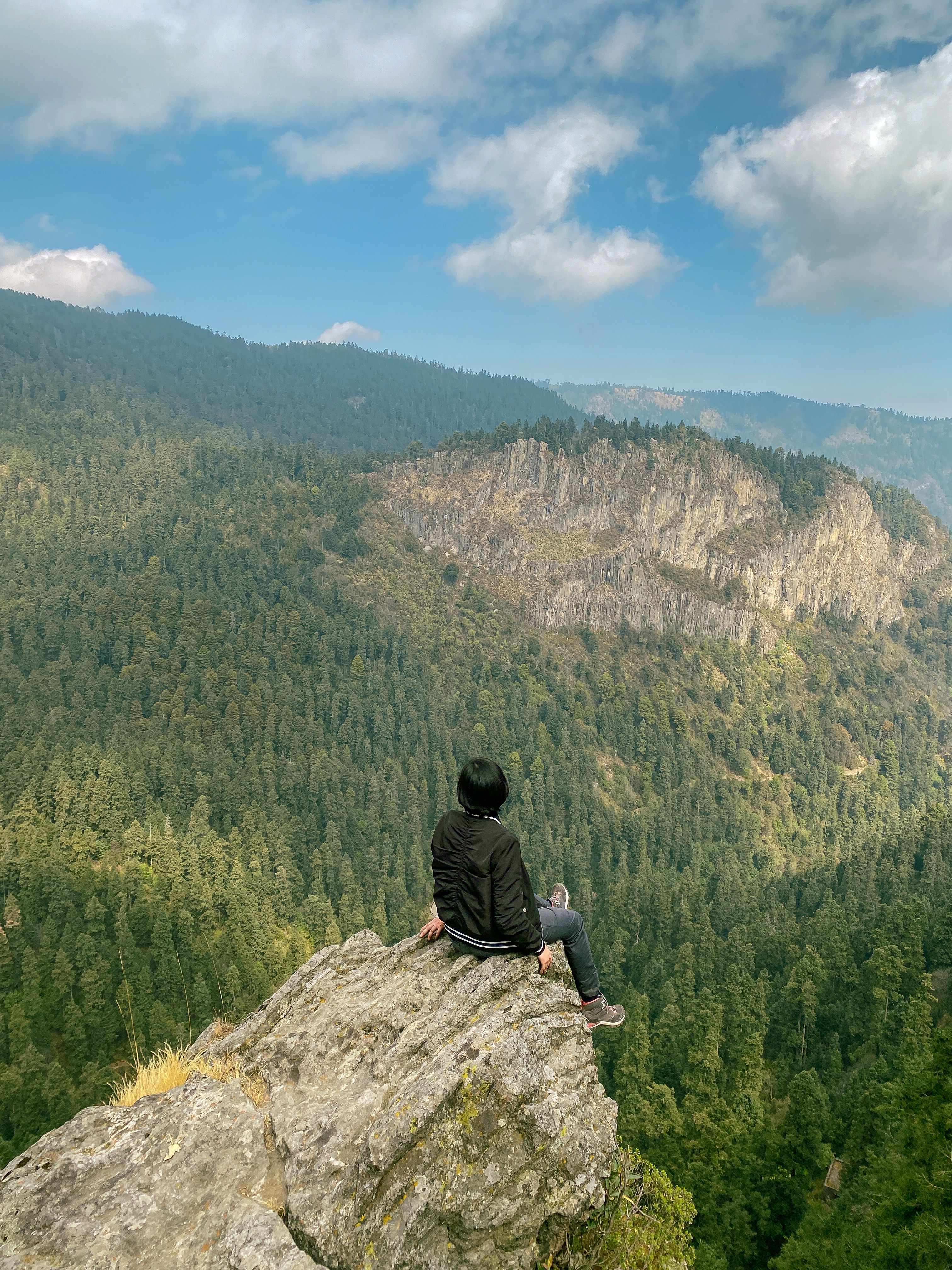 Man Sitting on a Rock in a Mountain Valley · Free Stock Photo
