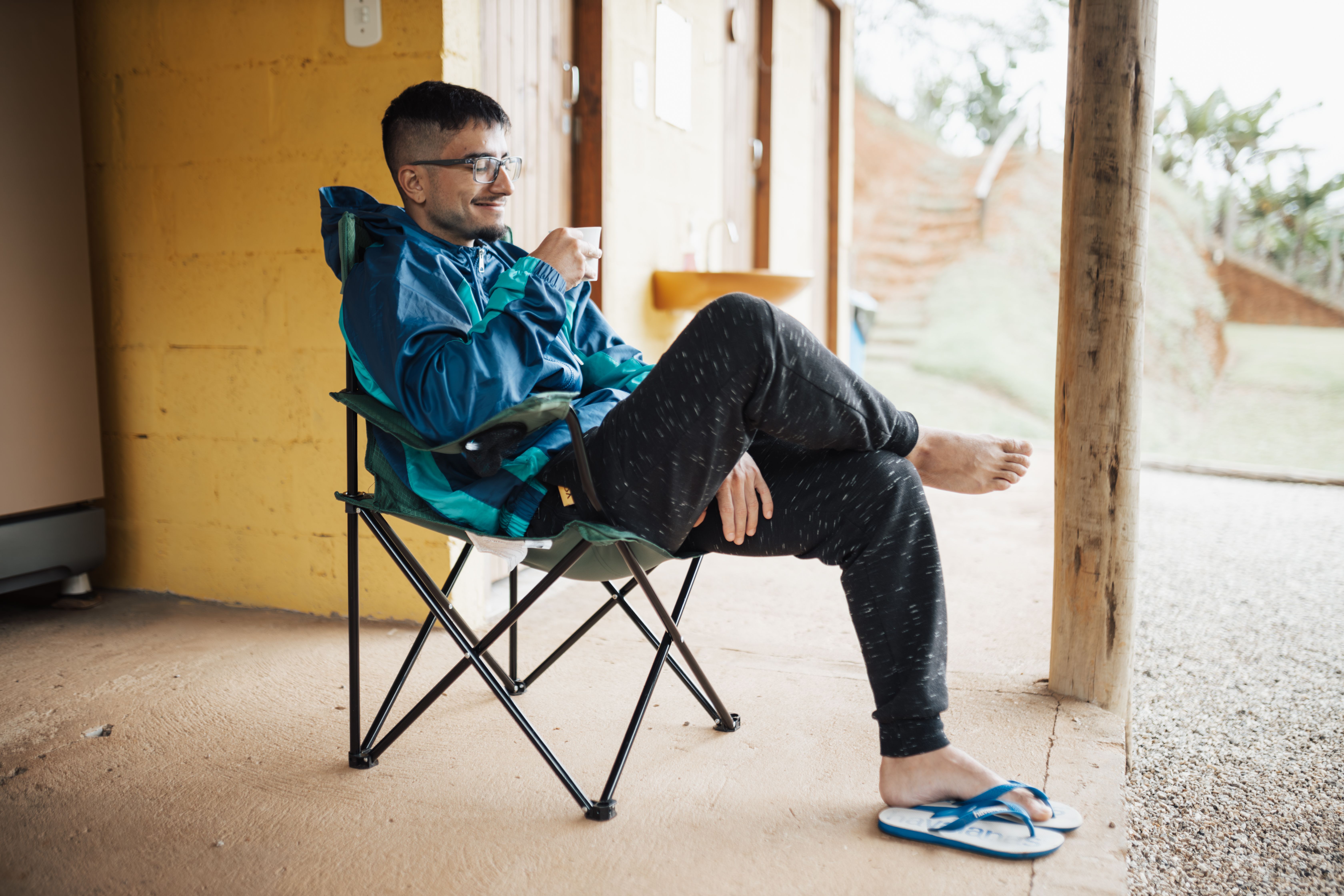person sitting on porch at sunrise with coffee, no phone visible, peaceful morning scene
