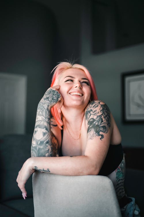Young Tattooed Woman Sitting on a Chair 