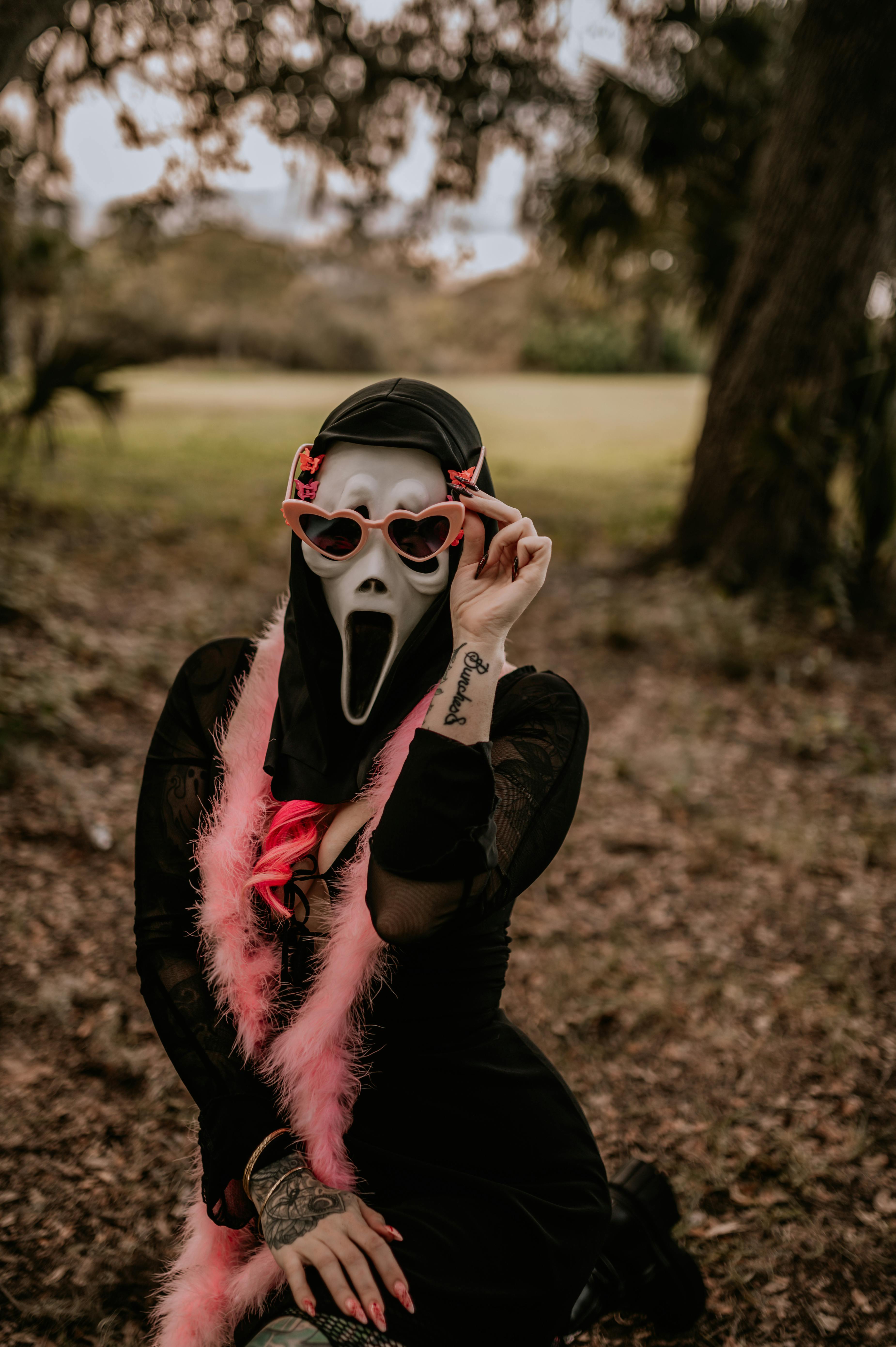 A person in a spooky mask and playful costume outdoors, embodying funny Halloween spirit.