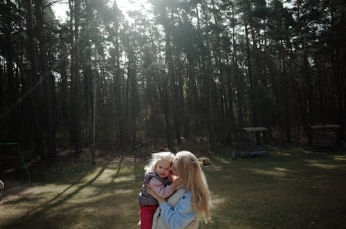 A woman holding a child in the woods