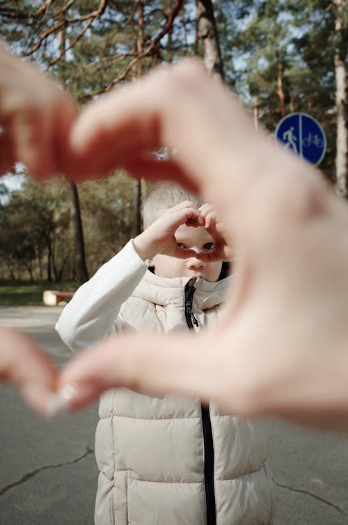 A person making a heart shape with their hands