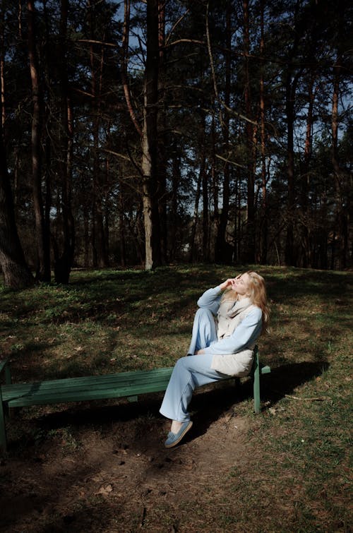 A woman sitting on a bench in the woods