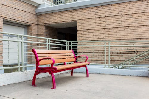 A red bench sits in front of a building
