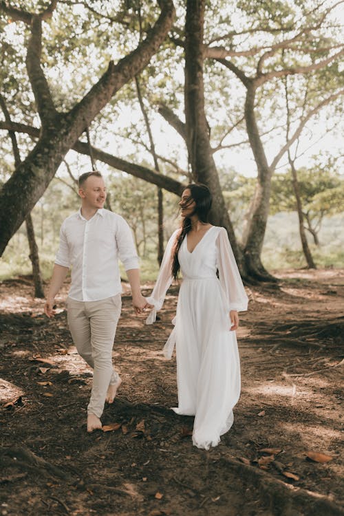 Free A couple walking through the woods during their elopement Stock Photo