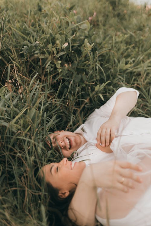 Free Just Married Couple Laying in the Grass Stock Photo