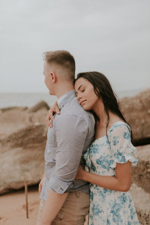 A couple hugging on the beach during their engagement session